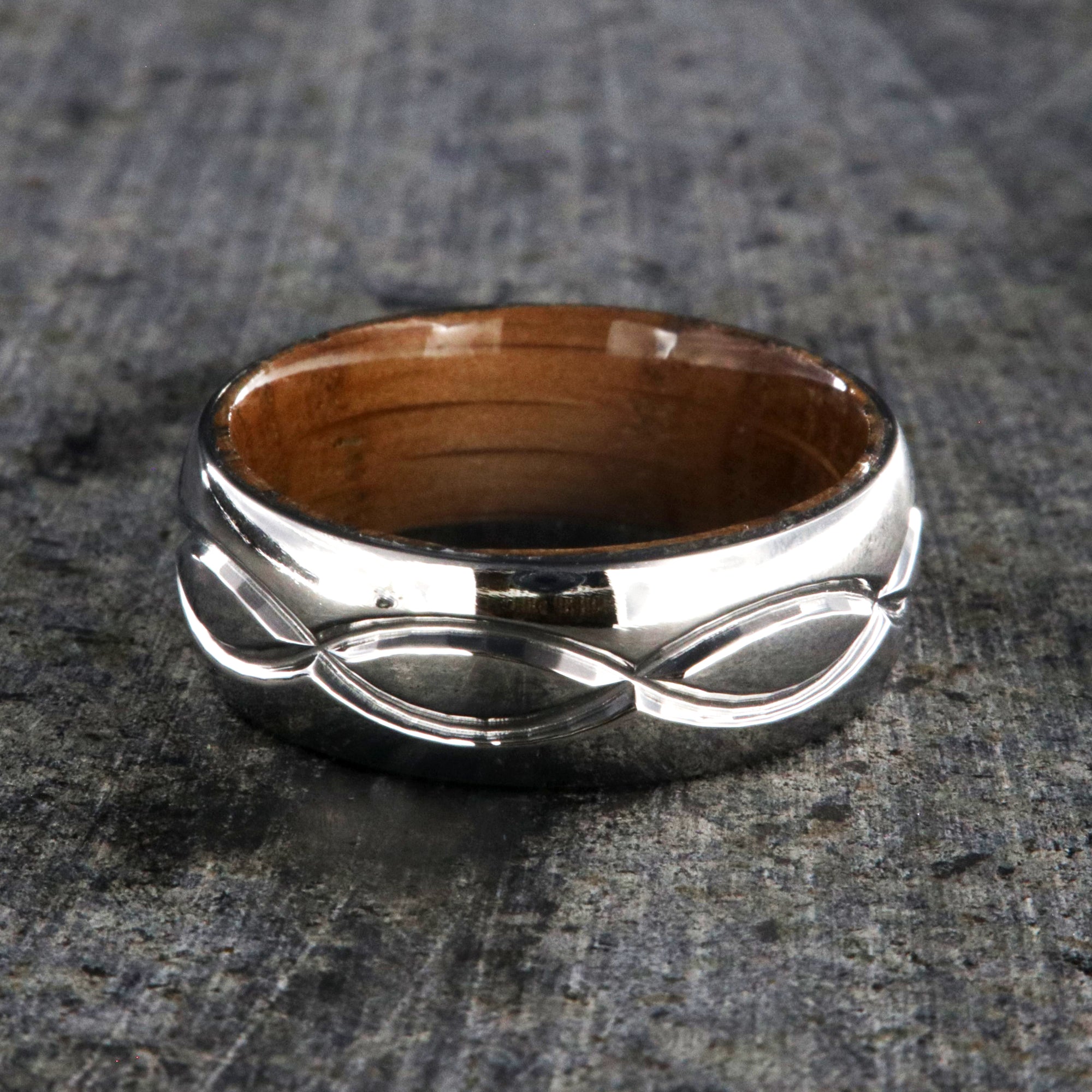 8mm wide titanium wedding band with a milled infinity design with a whiskey barrel sleeve