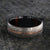 7mm wide men's Damascus steel wedding ring with a thin centered rose gold inlay and Arizona ironwood sleeve