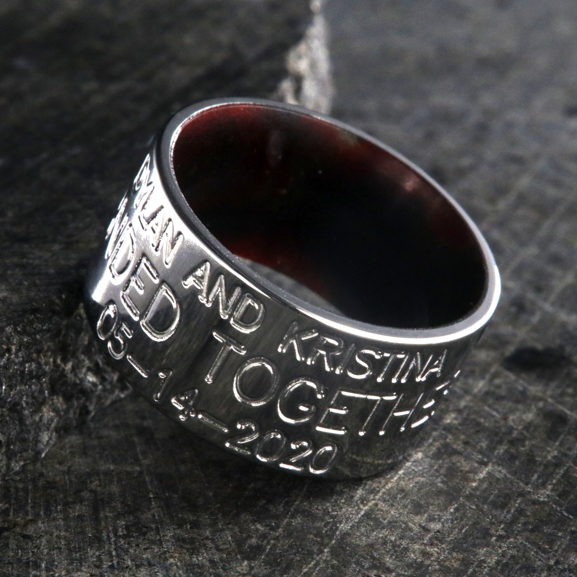 12mm wide titanium duck band ring with 3 lines of text with a dark red sleeve