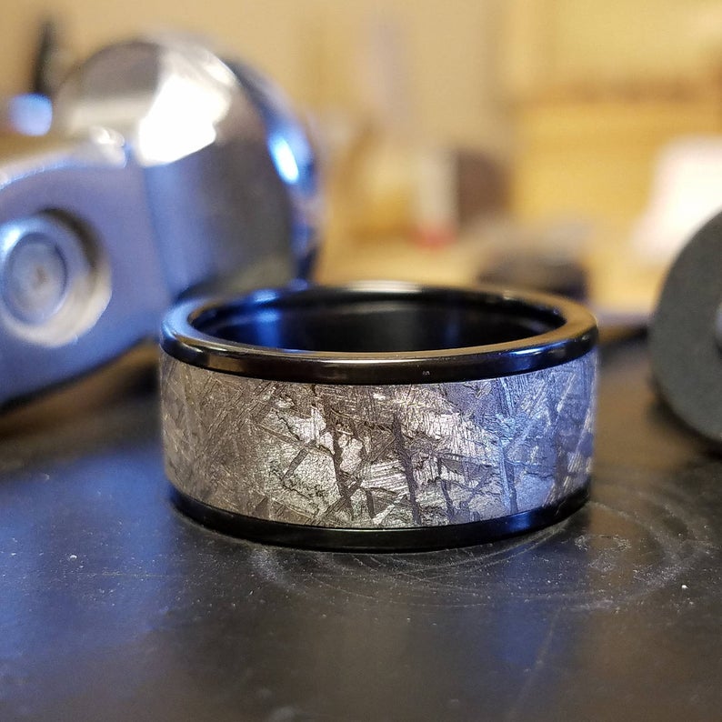 10mm wide meteorite wedding band with black titanium edges and sleeve with a flat profile