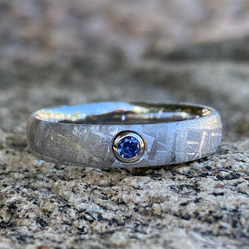 5mm wide women's meteorite ring with rounded profile and a blue sapphire set in a gold bezel
