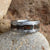 8mm wide meteorite ring with a cobalt sleeve, meteorite edges, and a combination of dinosaur bone and obsidian centered inlay