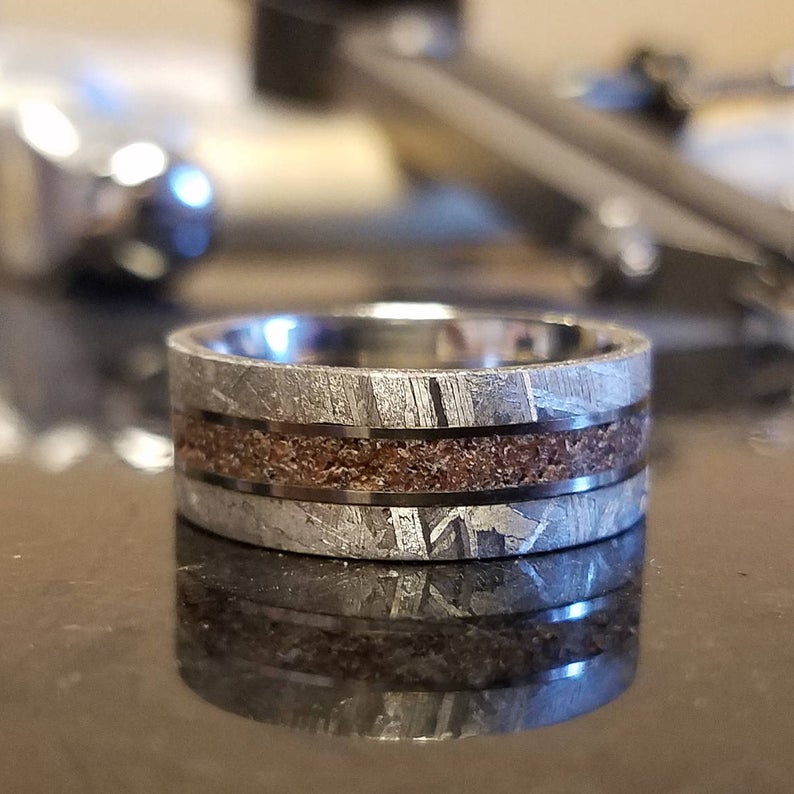 8mm wide Gibeon meteorite wedding ring for men with a dinosaur bone centered inlay with titanium sleeve