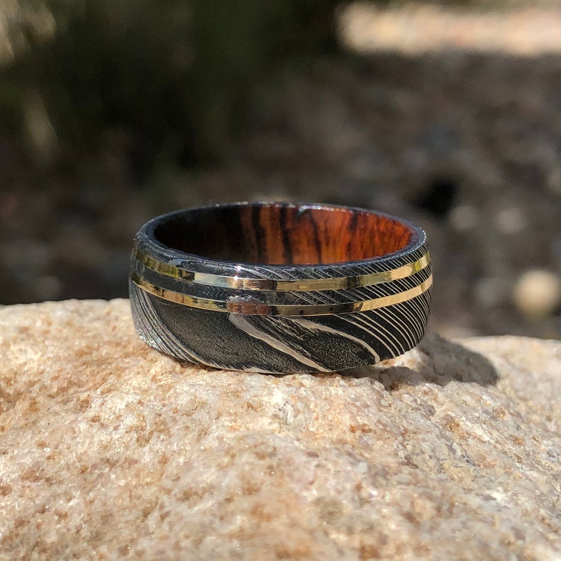 9mm wide black Damascus steel with a dual 14k yellow gold inlay and Arizona ironwood sleeve