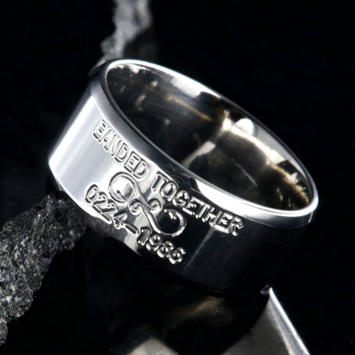 10mm wide titanium duck band with beveled edges and two lines of personalized text above and below an infinity hook design