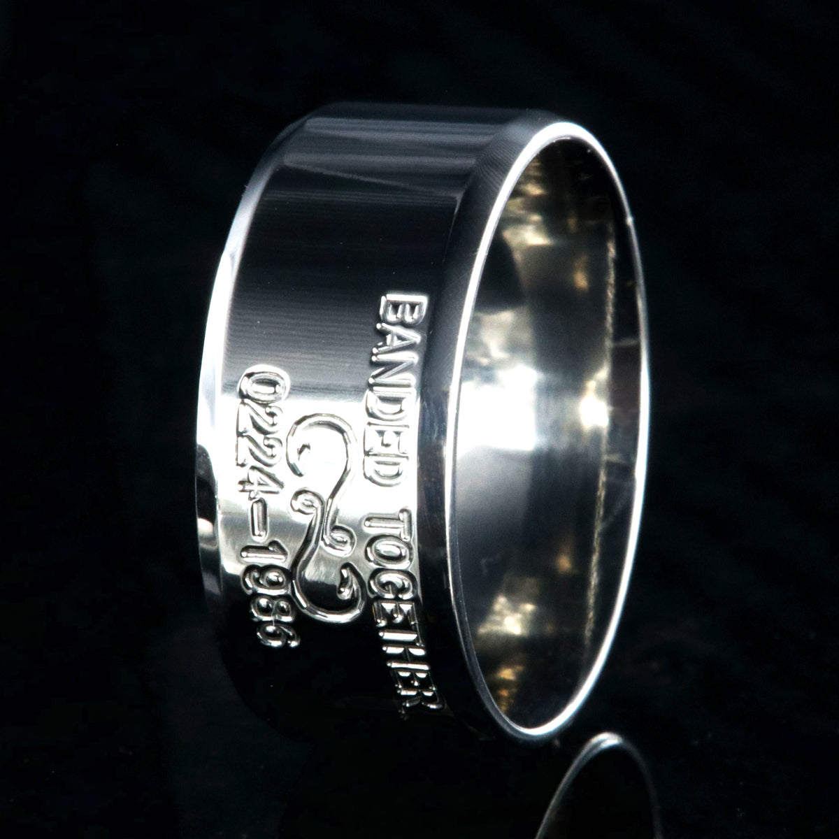 10mm wide titanium duck band with beveled edges and two lines of personalized text above and below an infinity hook design