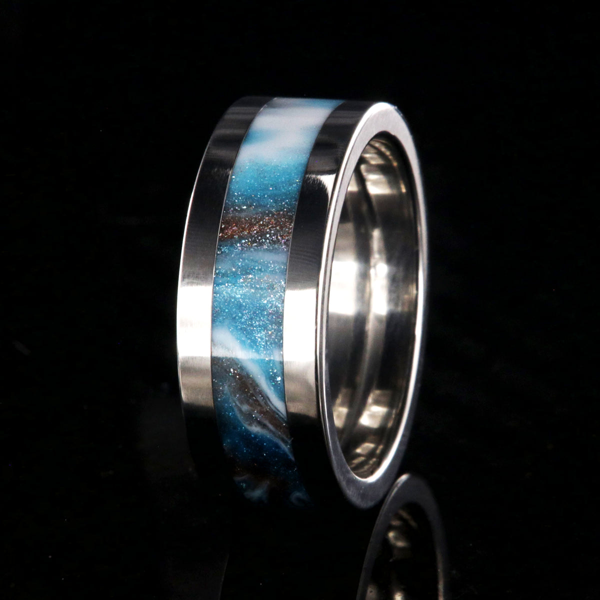 8mm wide titanium ring with blue, white, and brown glittering inlay