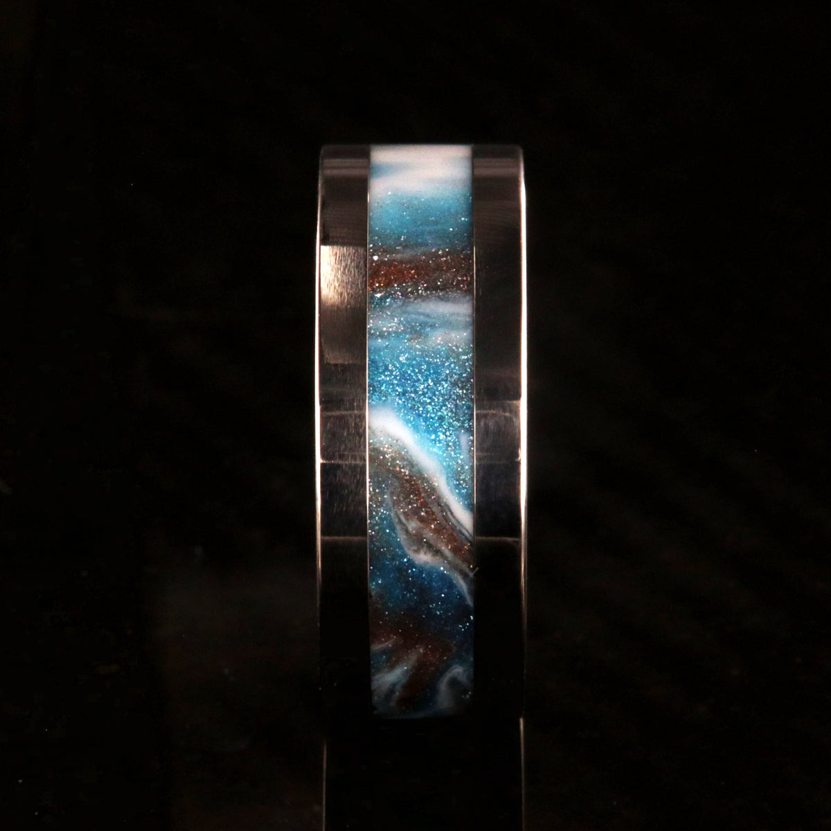 8mm wide titanium ring with blue, white, and brown glittering inlay