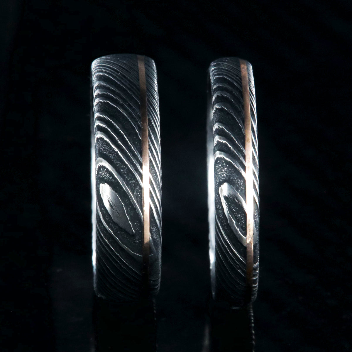 6mm and 4mm wide matching Damascus steel wedding bands with a ultra-narrow rose gold inlay