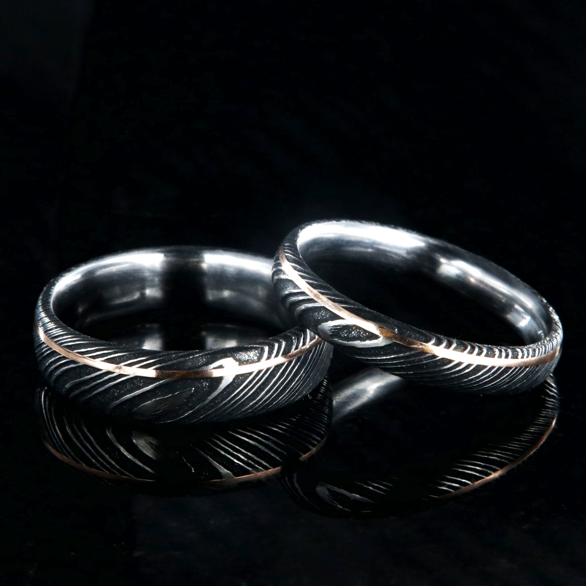 6mm and 4mm wide matching Damascus steel wedding bands with a ultra-narrow rose gold inlay