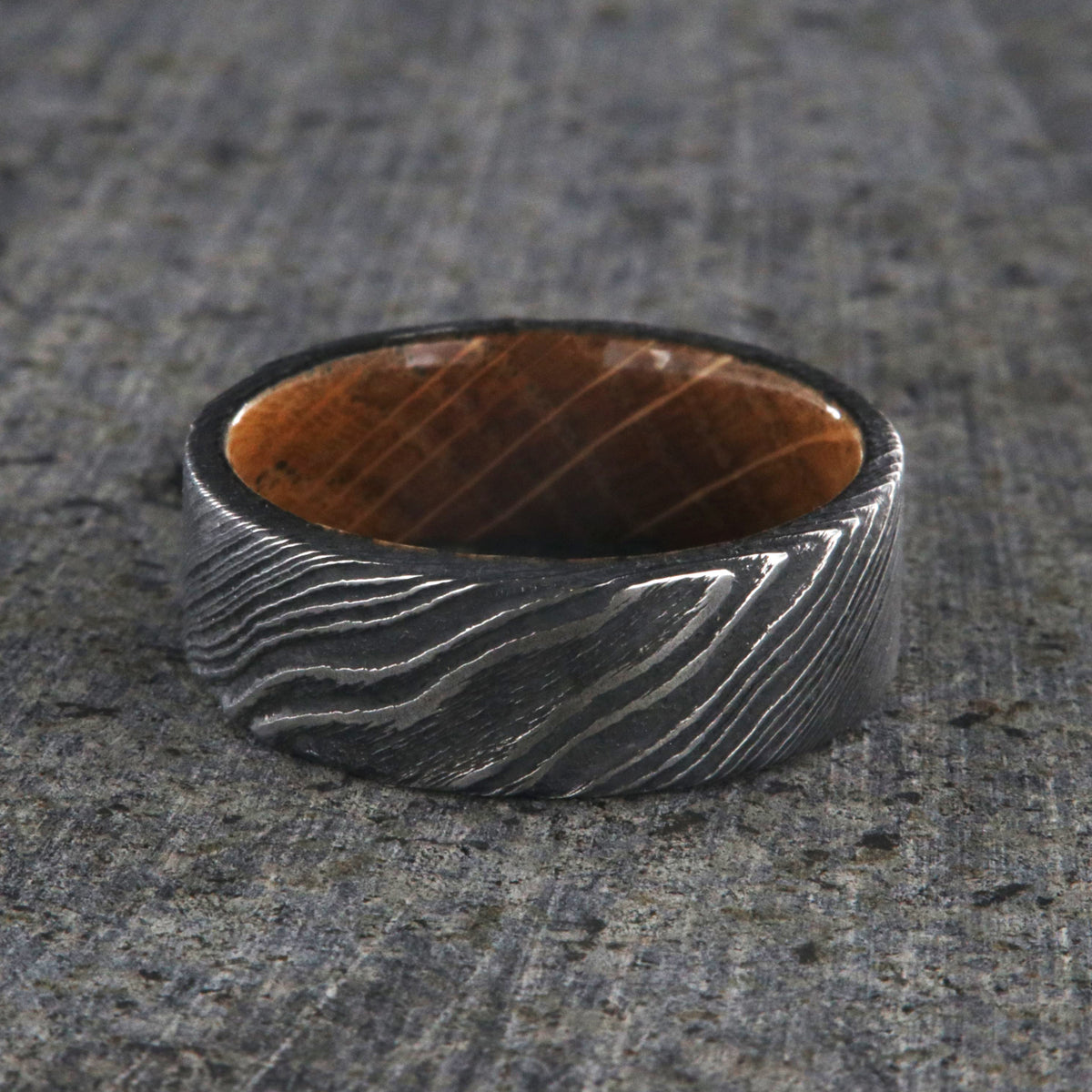 Flat profiled 8mm wide black Damascus steel ring with Jack Daniel&#39;s whiskey barrel sleeve