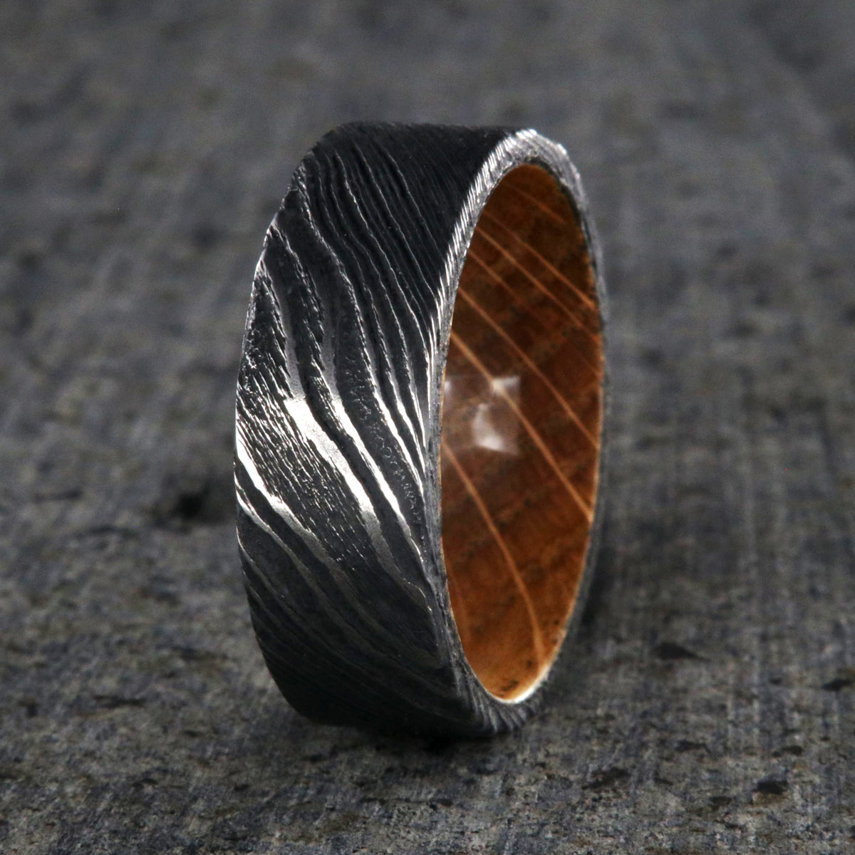 Flat profiled 8mm wide black Damascus steel ring with Jack Daniel&#39;s whiskey barrel sleeve