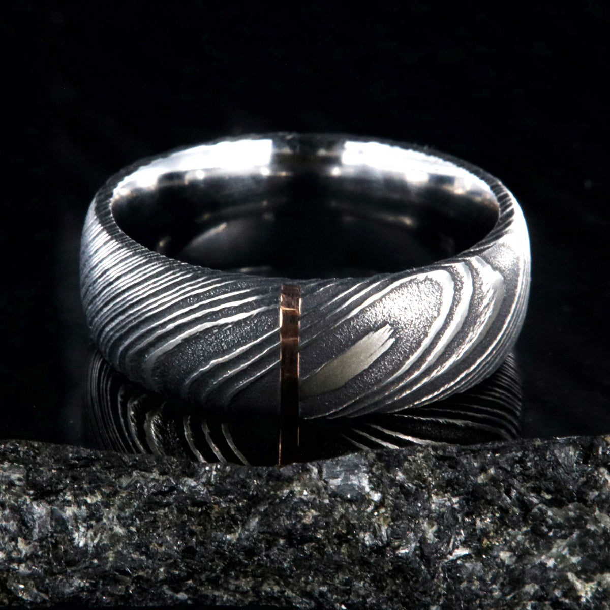 8mm wide black Damascus steel wedding band with a vertical groove of solid 14k rose gold