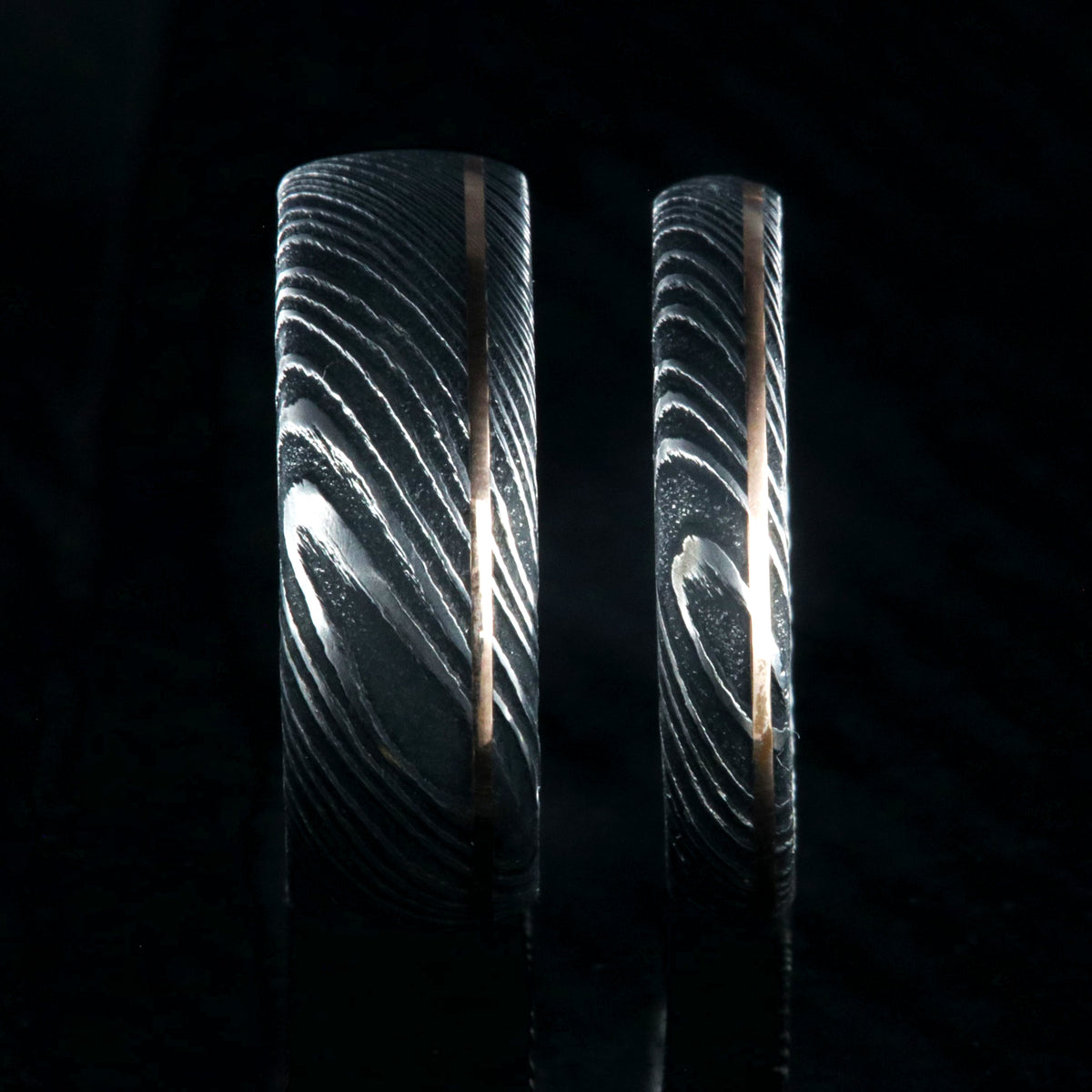 8mm and 4mm wide matching Damascus steel wedding bands with ultra-thin off-centered rose gold inlays