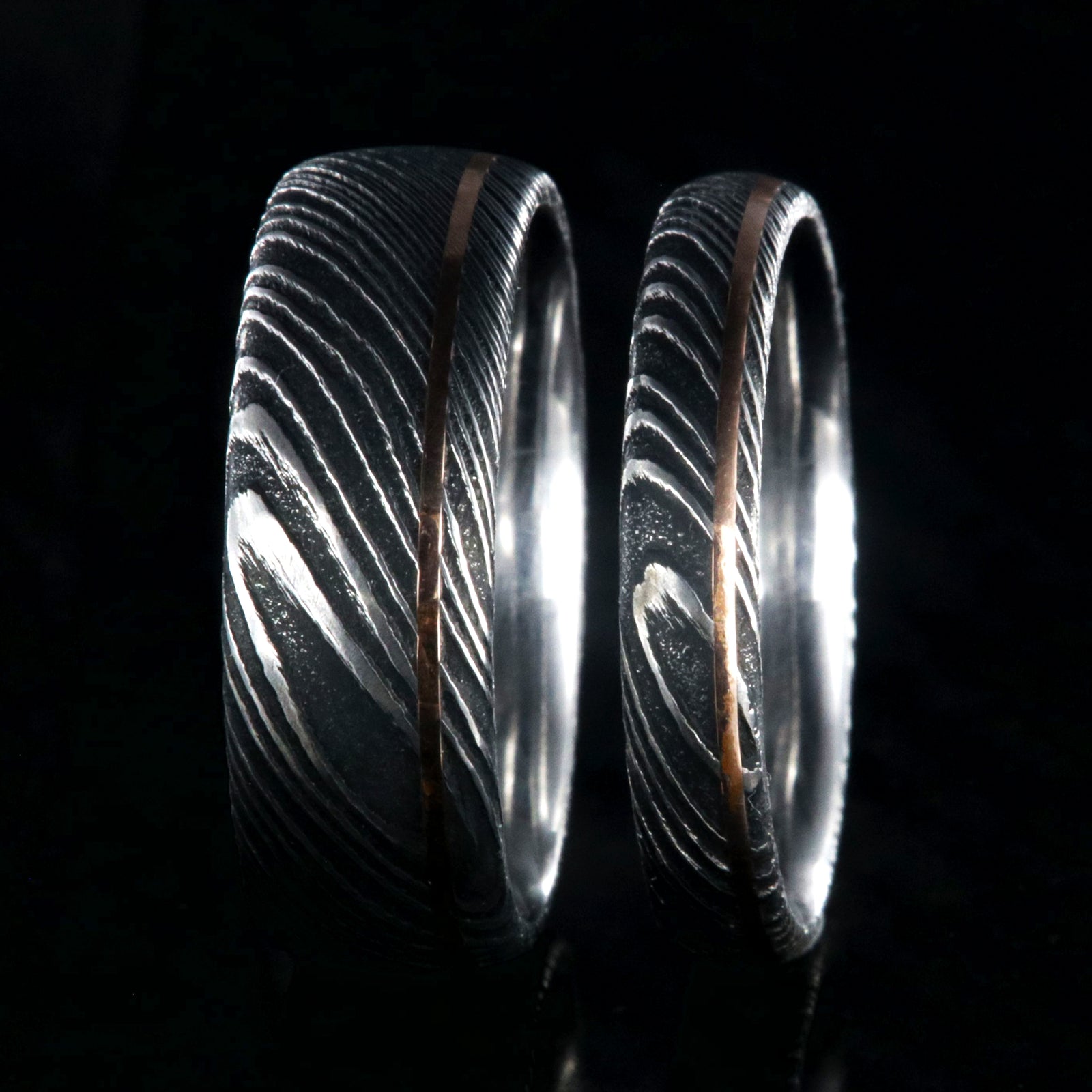 8mm and 4mm wide matching Damascus steel wedding bands with ultra-thin off-centered rose gold inlays
