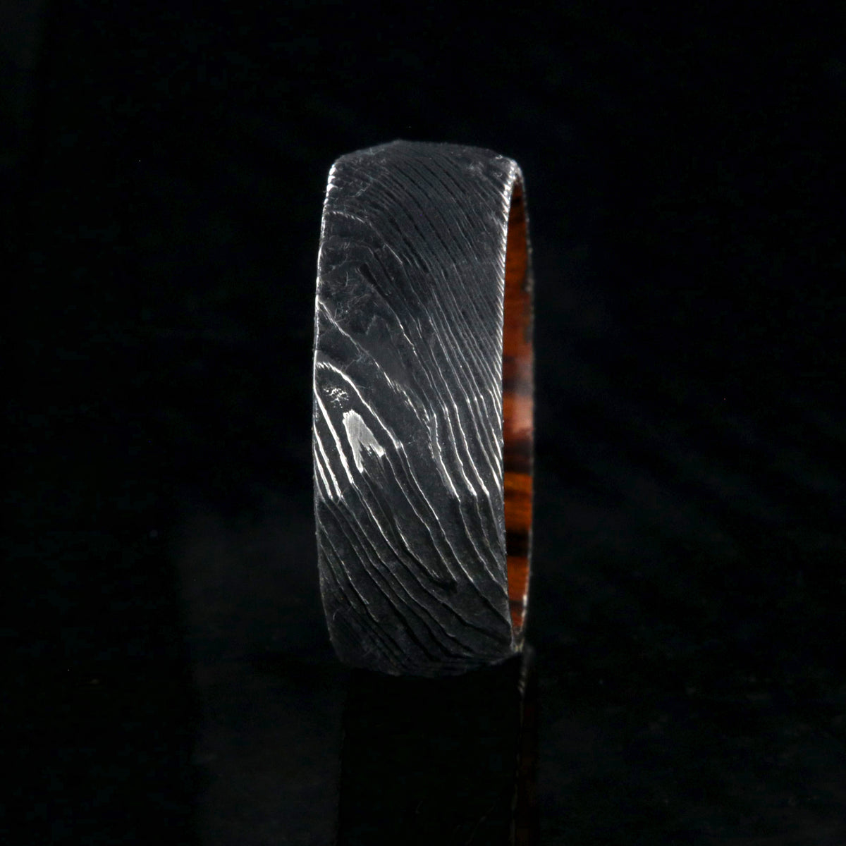 8mm wide black Damascus steel men&#39;s wedding band with an Arizona ironwood sleeve and hammered band finish