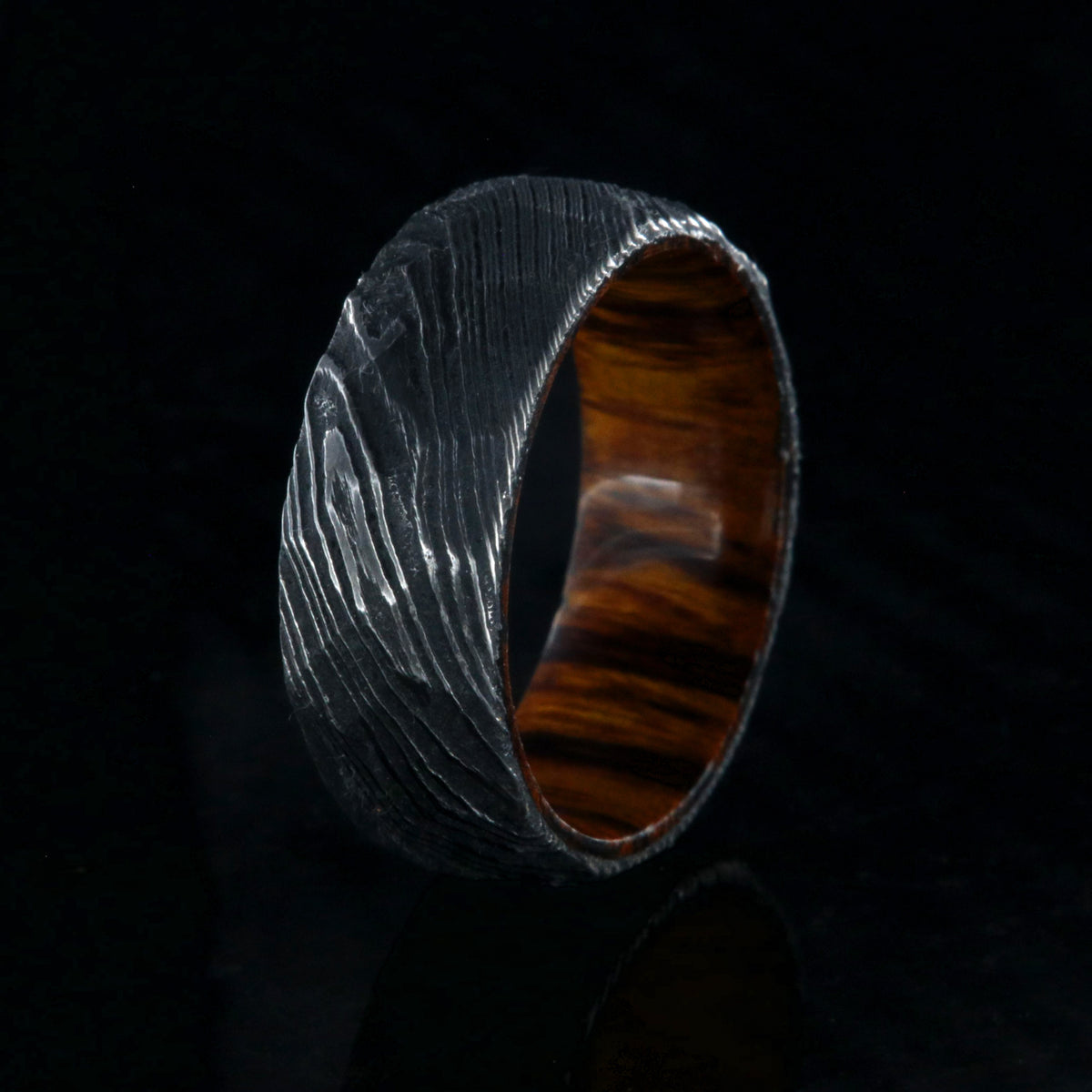 8mm wide black Damascus steel men&#39;s wedding band with an Arizona ironwood sleeve and hammered band finish