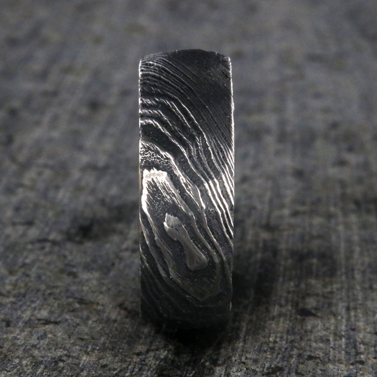 8mm wide big hammered texture on a Damascus steel wedding ring with a whiskey barrel sleeve