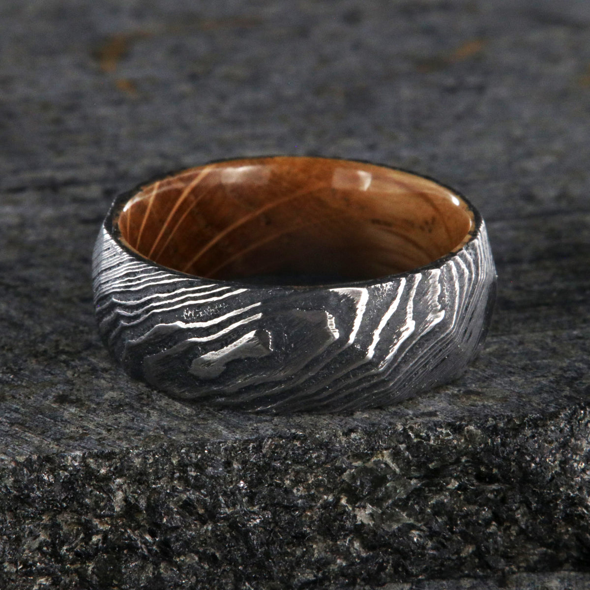 8mm wide big hammered texture on a Damascus steel wedding ring with a whiskey barrel sleeve