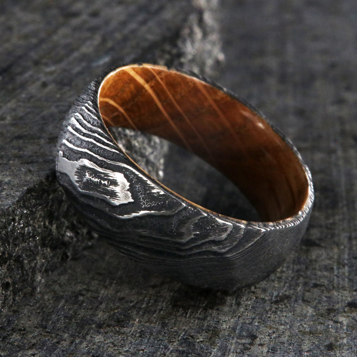 8mm wide big hammered texture on a Damascus steel wedding ring with a whiskey barrel sleeve