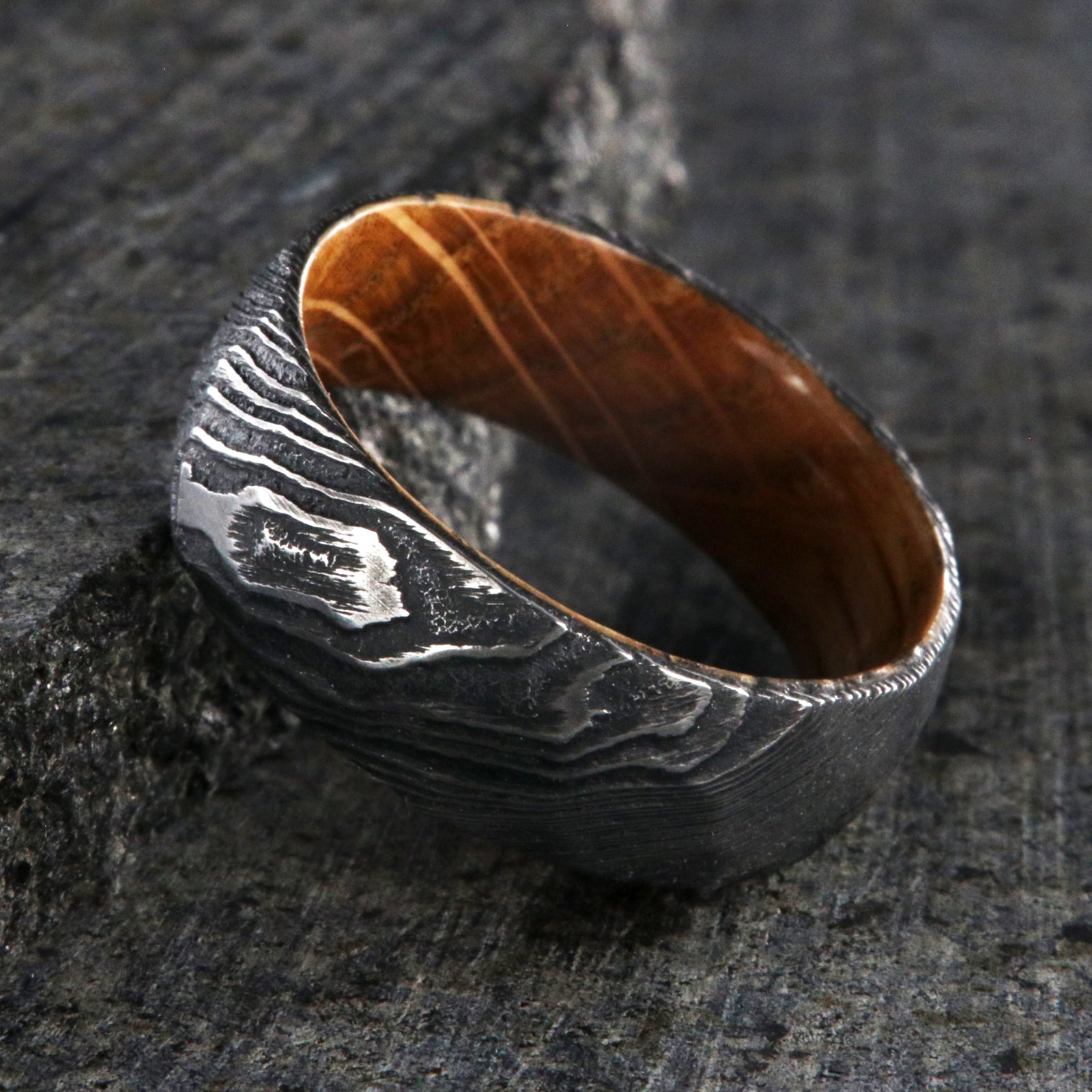 8mm wide big hammered texture on a Damascus steel wedding ring with a whiskey barrel sleeve