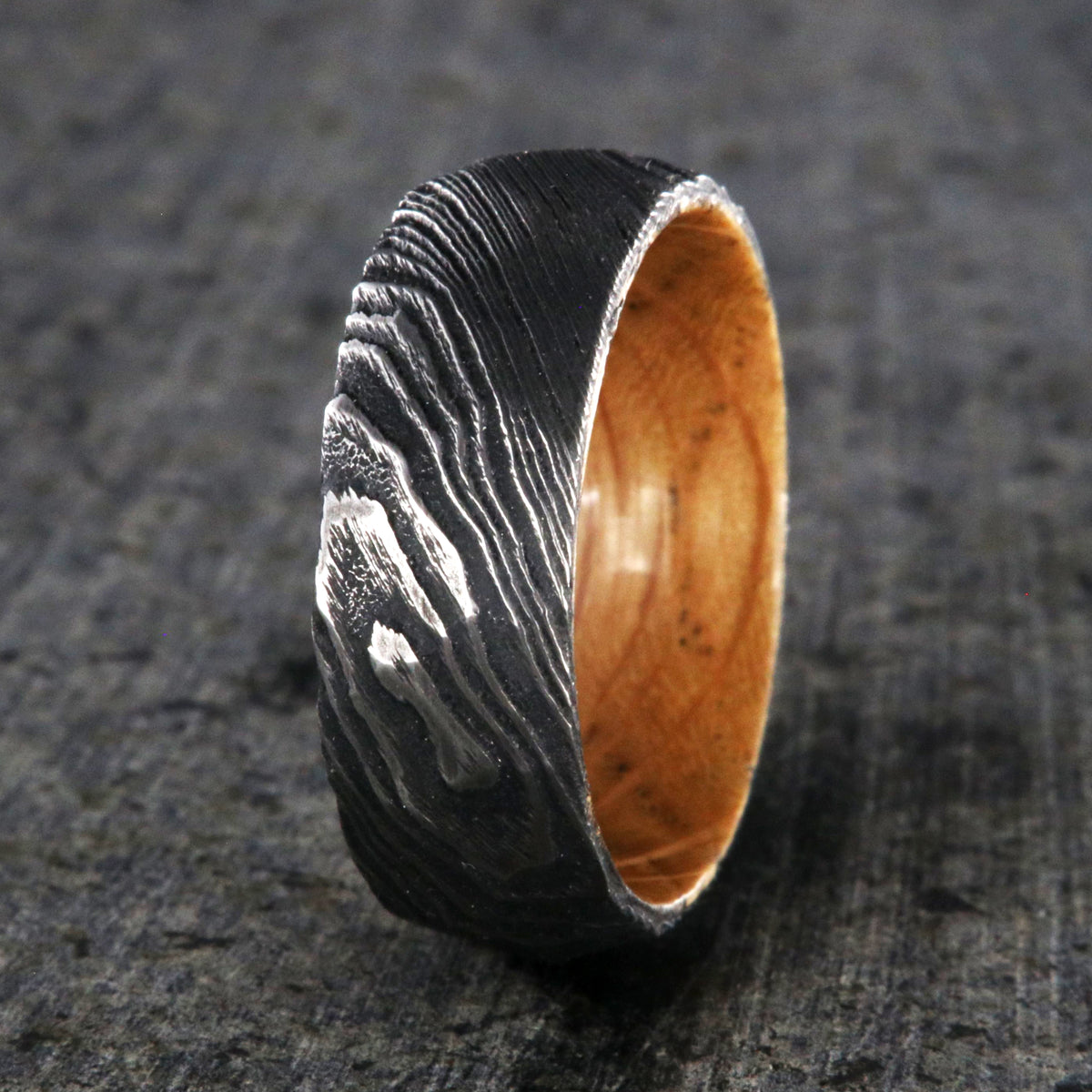 8mm wide big hammered texture on a Damascus steel wedding ring with a whiskey barrel sleeve