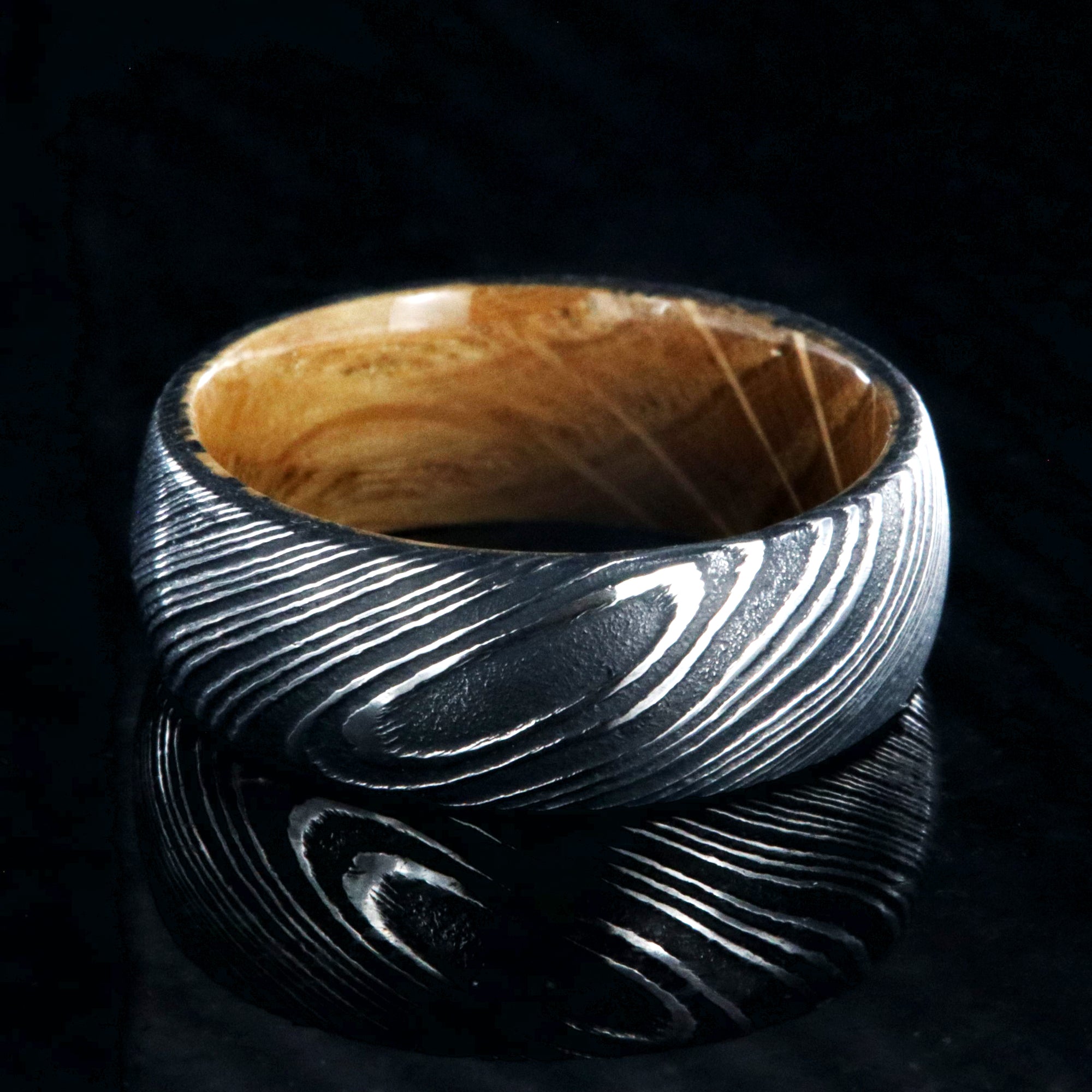8mm wide black Damascus steel ring with Jack Daniel's whiskey barrel sleeve and rounded profile
