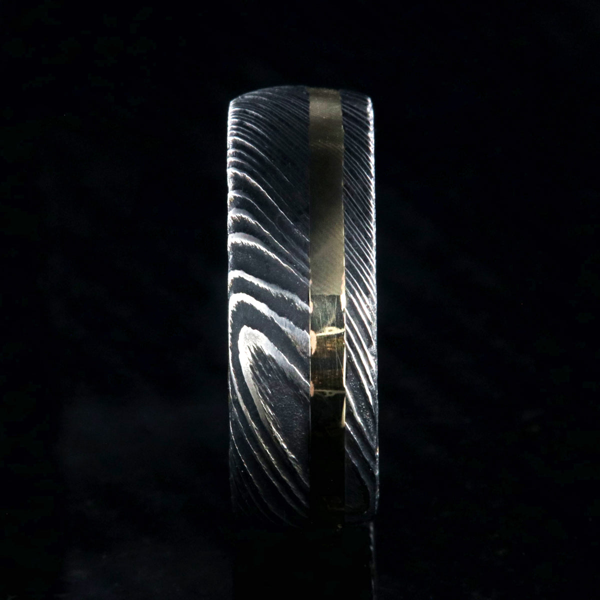 8mm wide black Damascus steel wedding ring with rounded profile, 2mm wide yellow gold inlay and a Jack Daniel&#39;s whiskey barrel sleeve