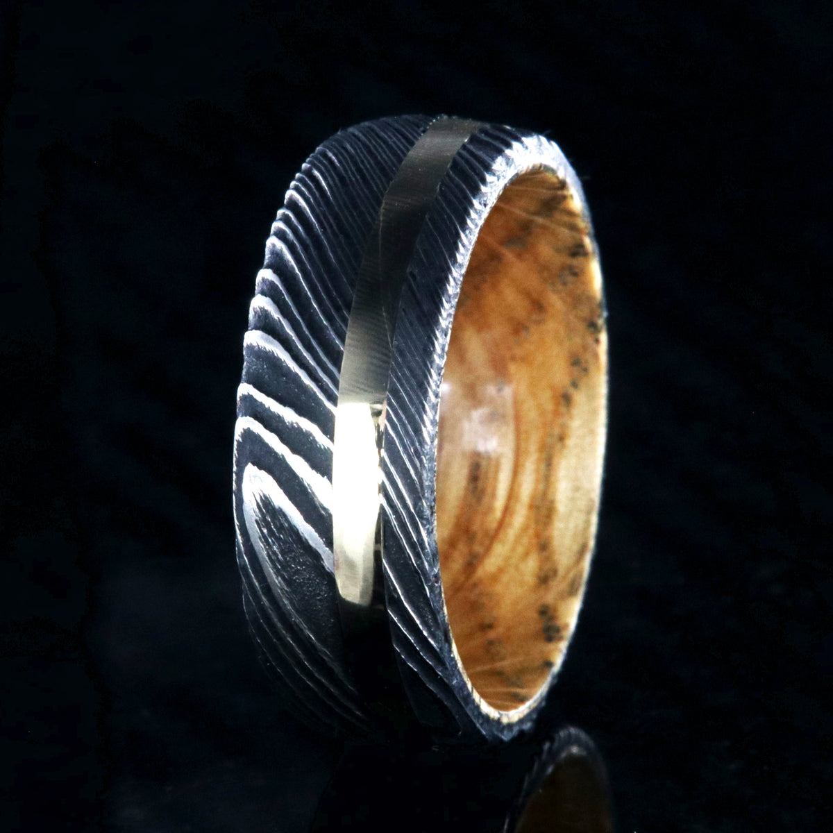 8mm wide black Damascus steel wedding ring with rounded profile, 2mm wide yellow gold inlay and a Jack Daniel&#39;s whiskey barrel sleeve
