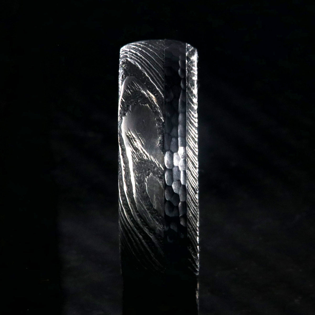 8mm wide black Damascus steel wedding ring with rounded profile, polished inside, and hammered black titanium inlay