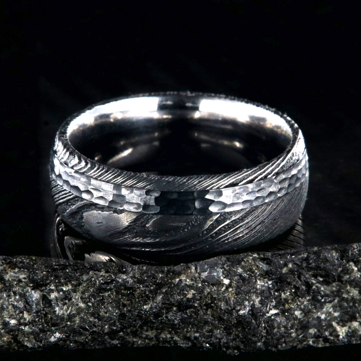 8mm wide black Damascus steel wedding ring with rounded profile, polished inside, and hammered black titanium inlay