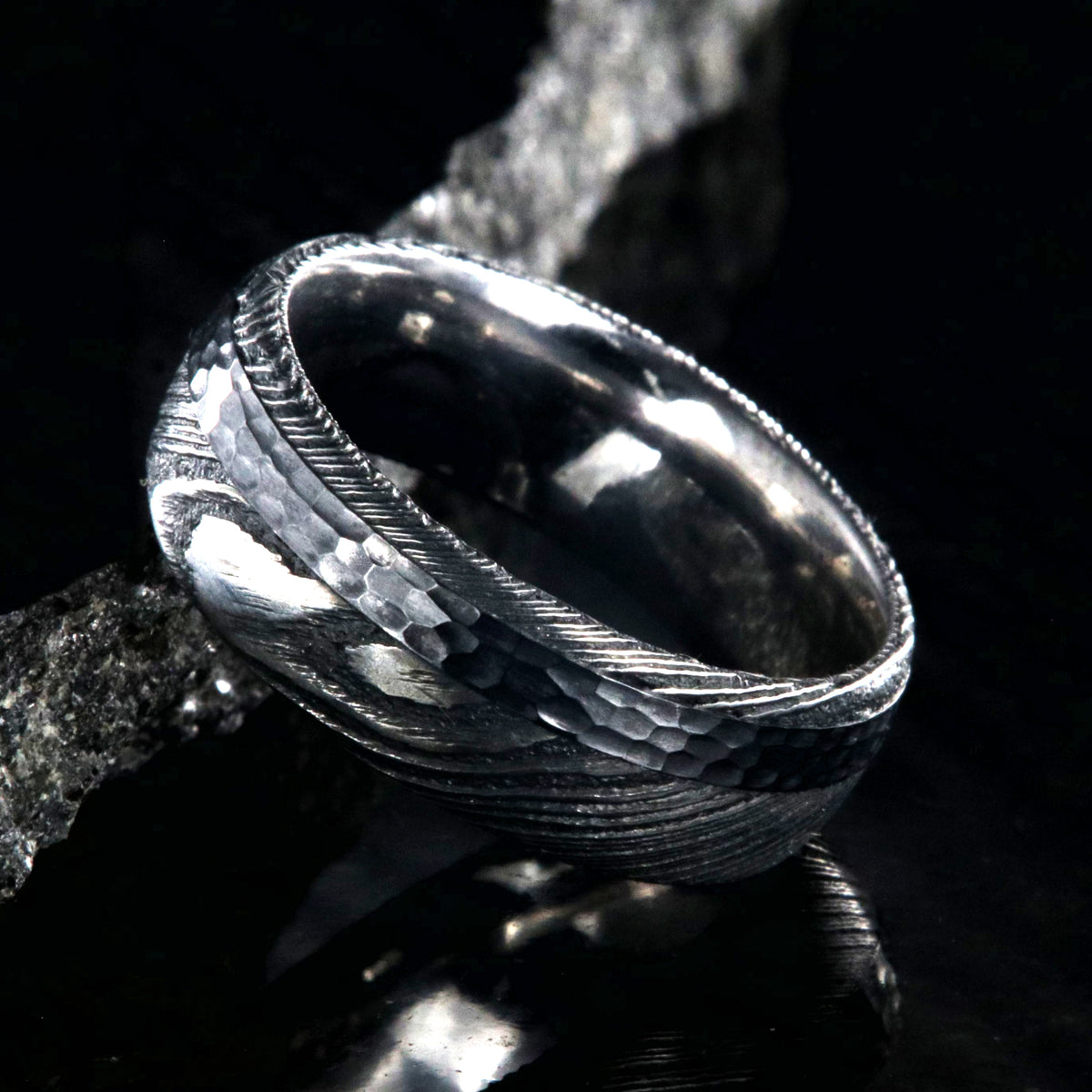 8mm wide black Damascus steel wedding ring with rounded profile, polished inside, and hammered black titanium inlay