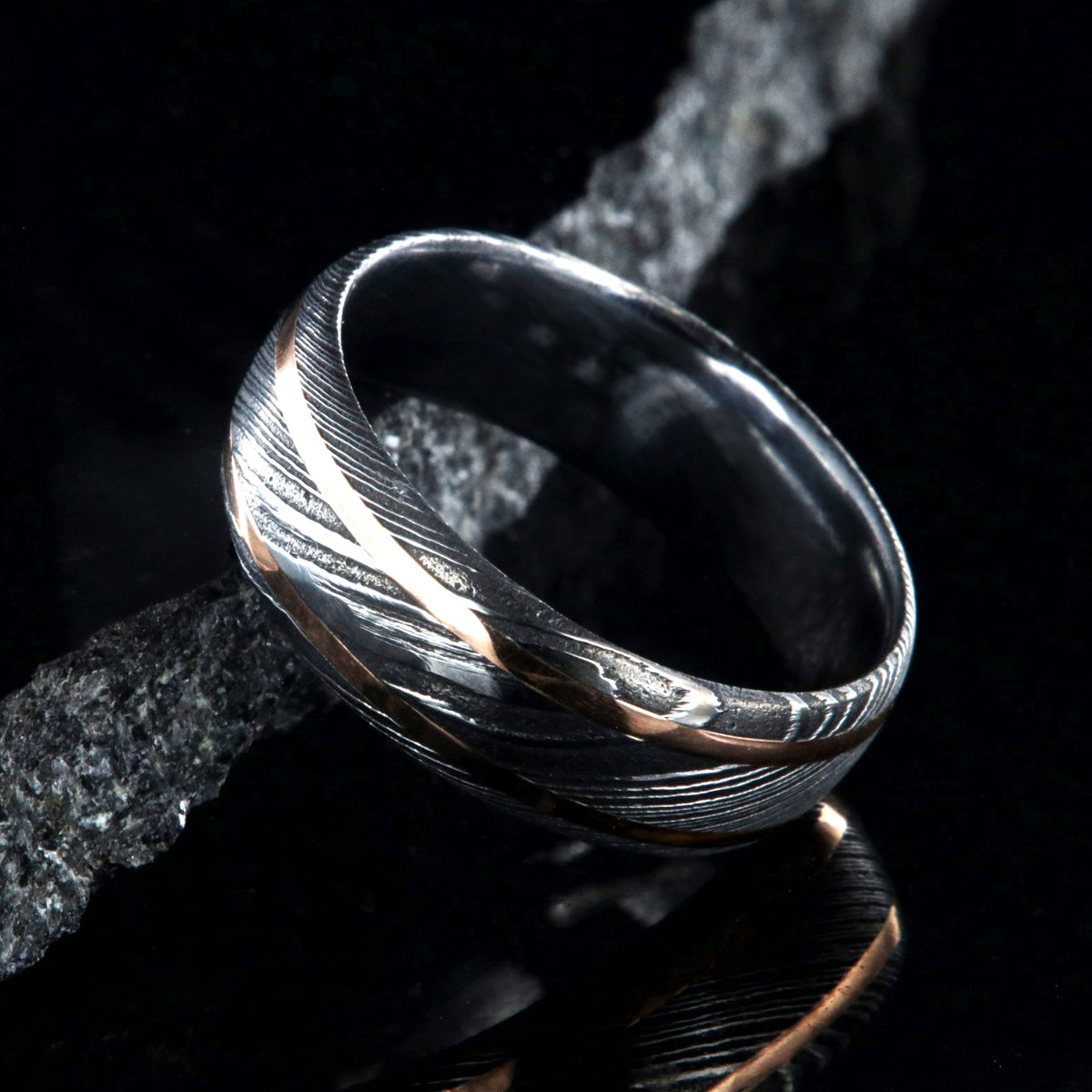 8mm wide black Damascus steel wedding ring with two thin edge rose gold  inlays and polished inside