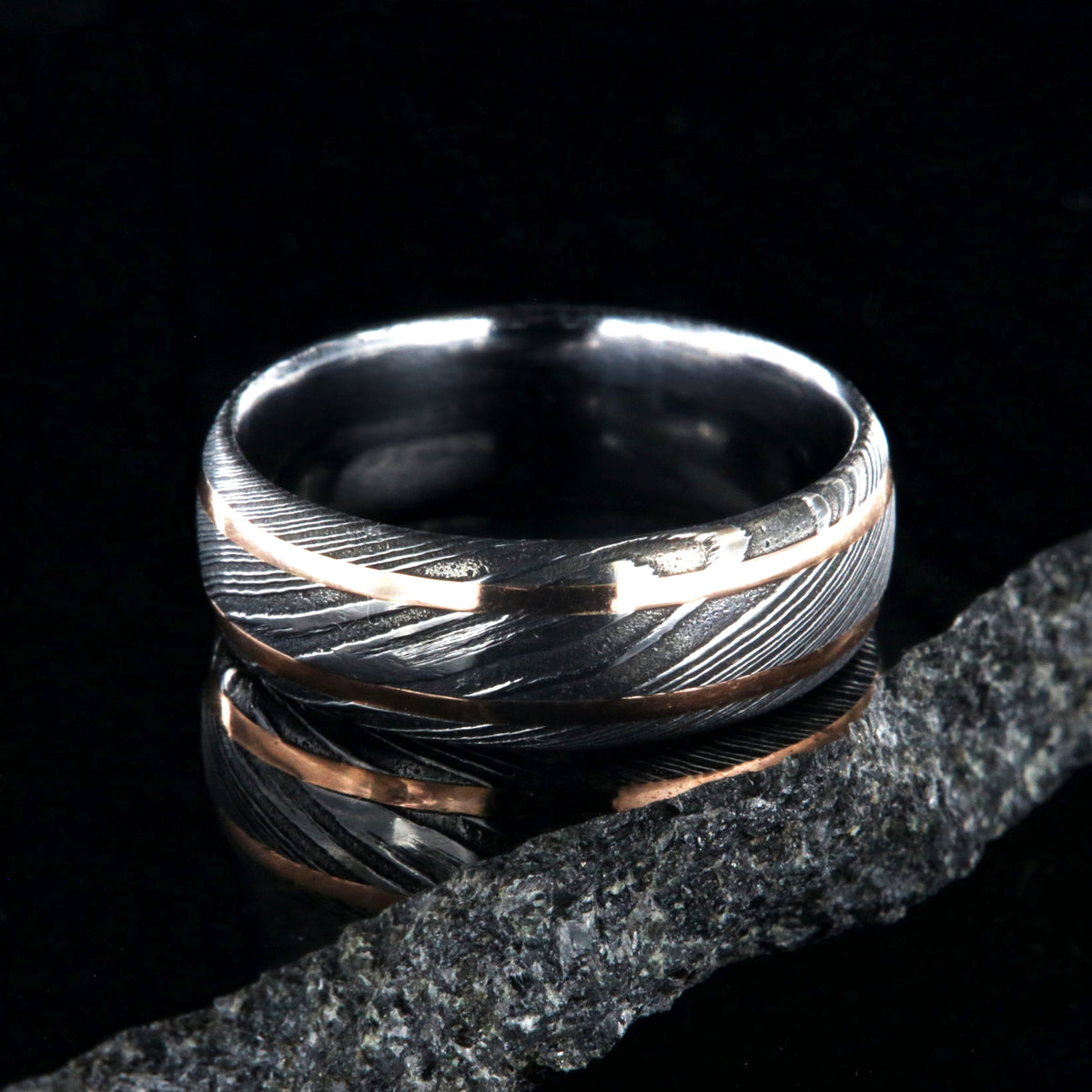8mm wide black Damascus steel wedding ring with two thin edge rose gold  inlays and polished inside