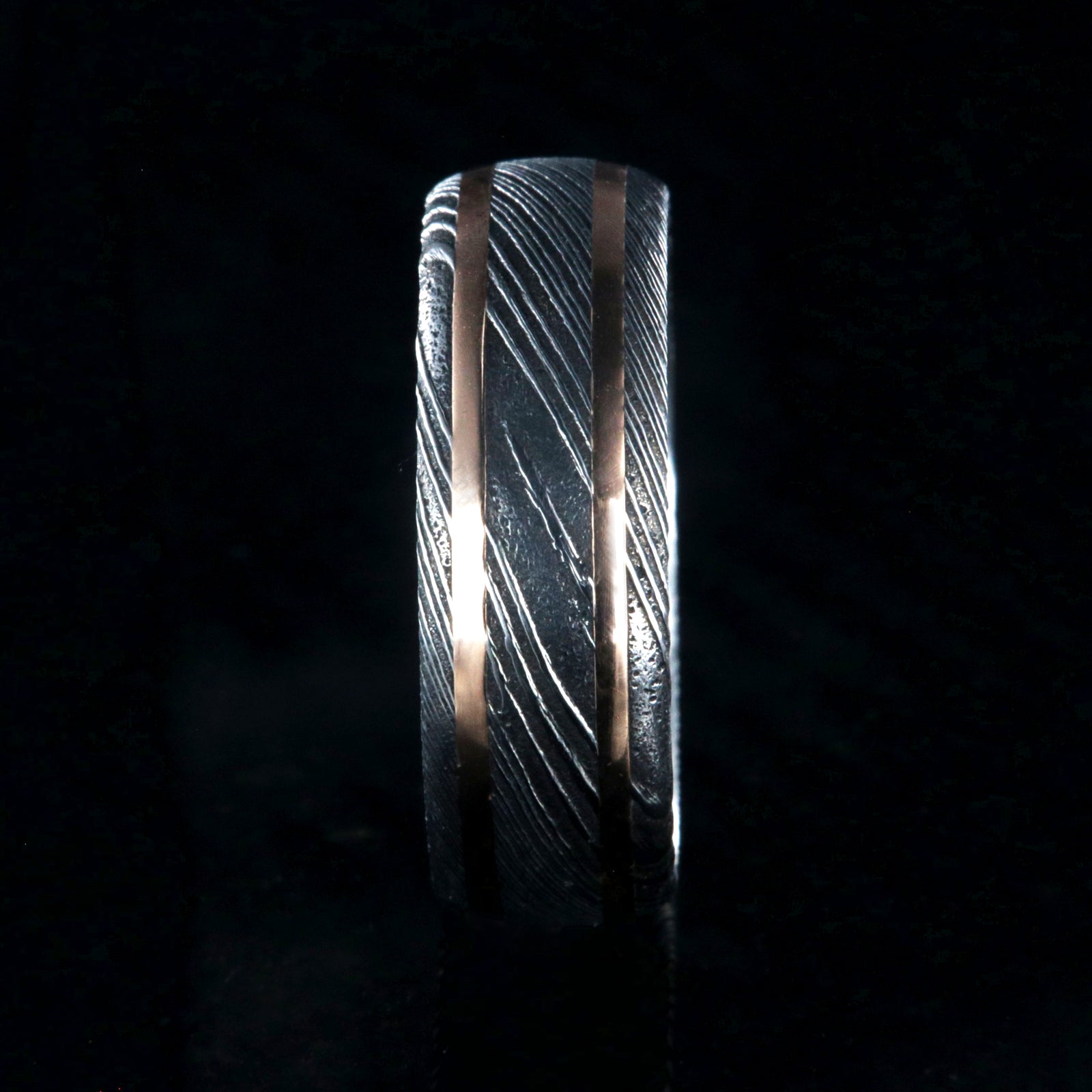 8mm wide black Damascus steel wedding ring with two thin edge rose gold  inlays and polished inside