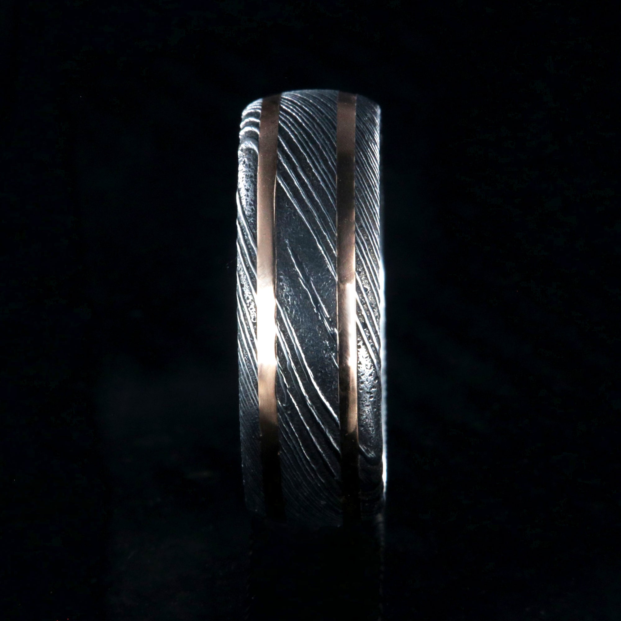 8mm wide black Damascus steel wedding ring with two thin edge rose gold  inlays and polished inside