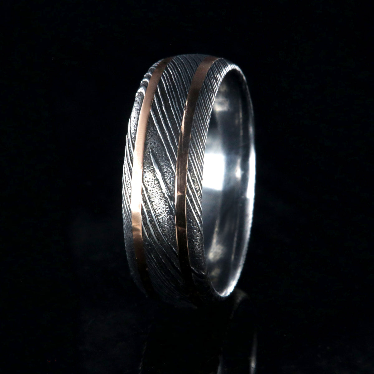 8mm wide black Damascus steel wedding ring with two thin edge rose gold  inlays and polished inside