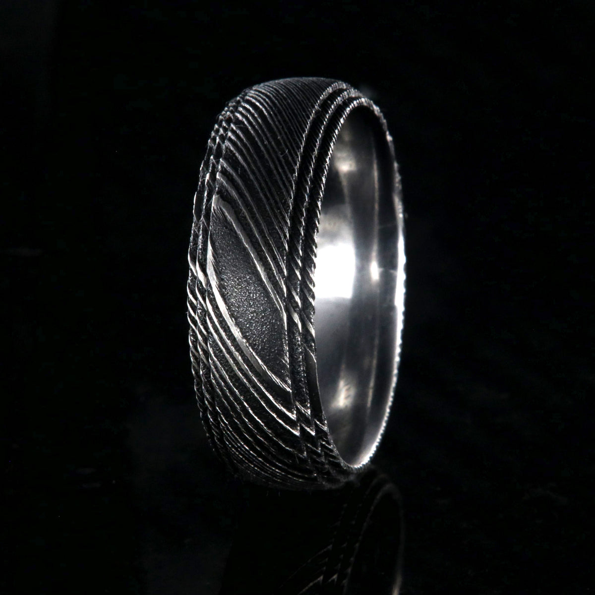 8mm wide black Damascus steel ring for men with a polish inside and a 2 step grooved edges