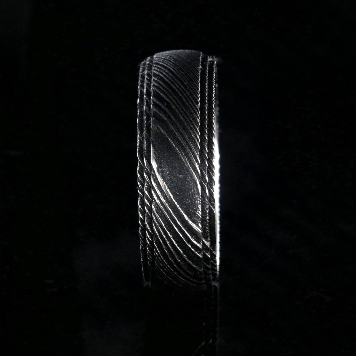 8mm wide black Damascus steel ring for men with a polish inside and a 2 step grooved edges