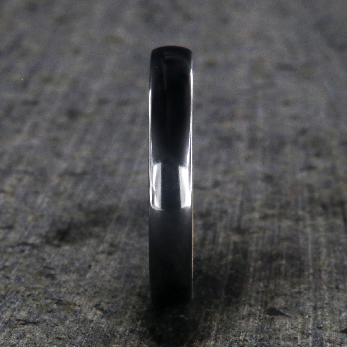 4mm wide black titanium wedding band with a rounded profile, polish finish, and whiskey barrel sleeve