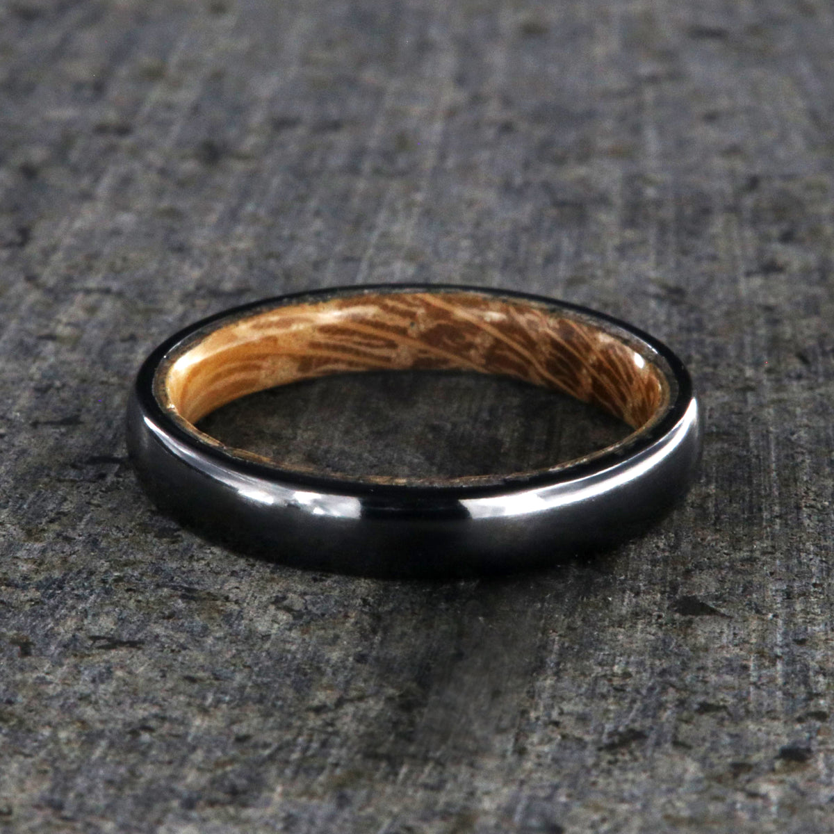 4mm wide black titanium wedding band with a rounded profile, polish finish, and whiskey barrel sleeve