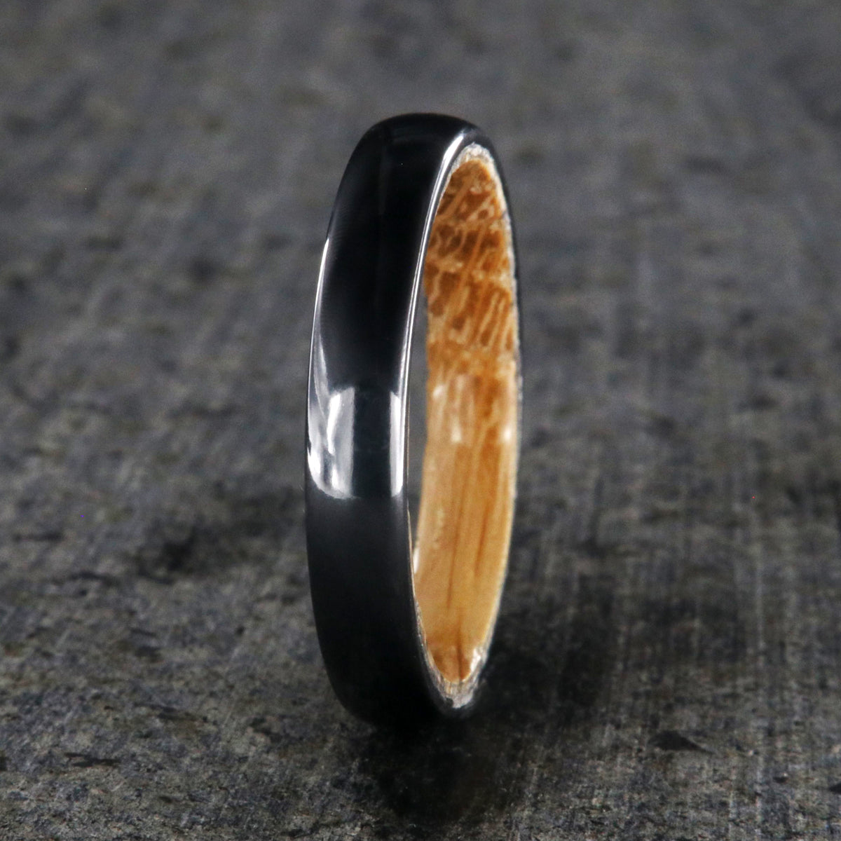 4mm wide black titanium wedding band with a rounded profile, polish finish, and whiskey barrel sleeve