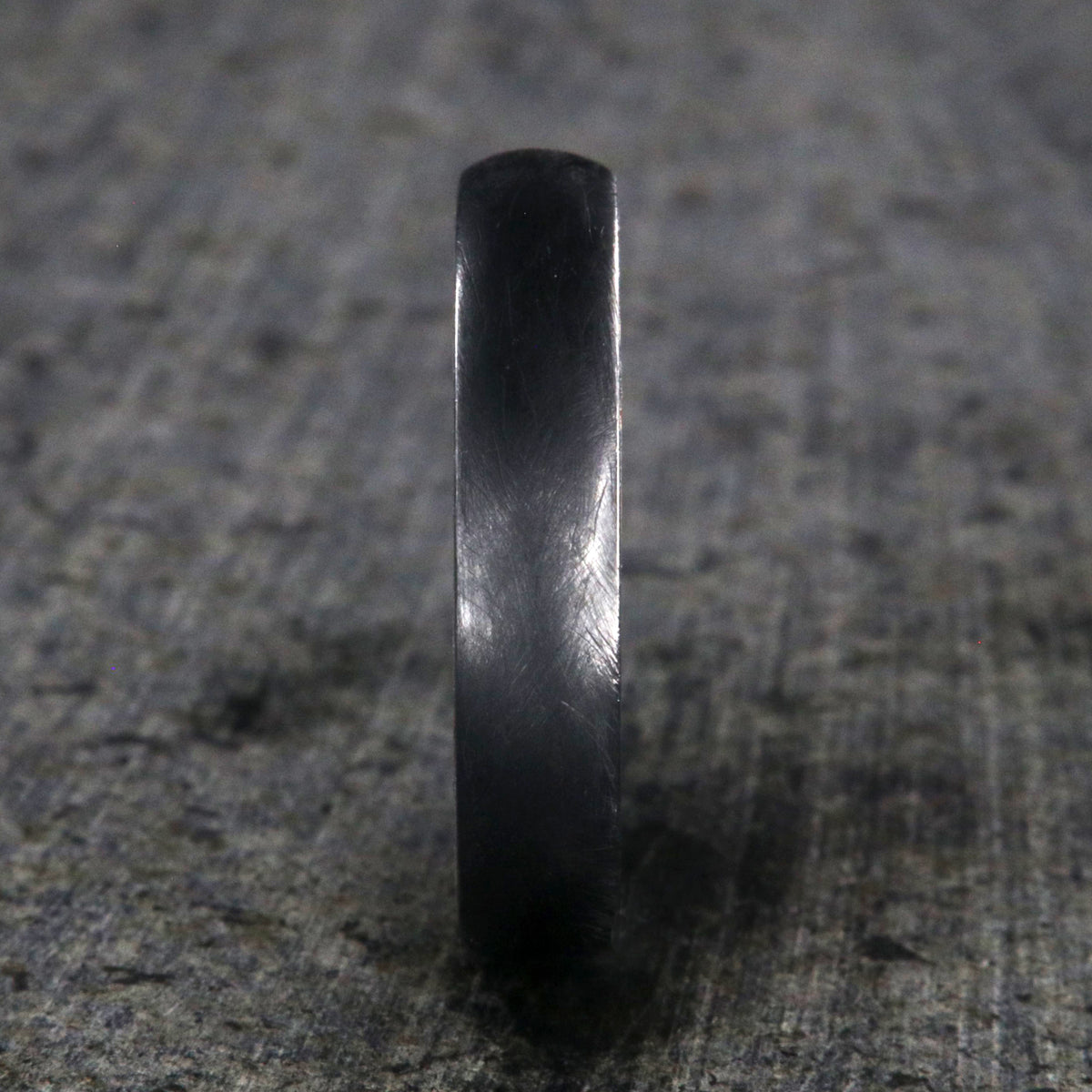 5mm wide black titanium wedding band with a distressed finish, rounded profile, and whiskey barrel sleeve