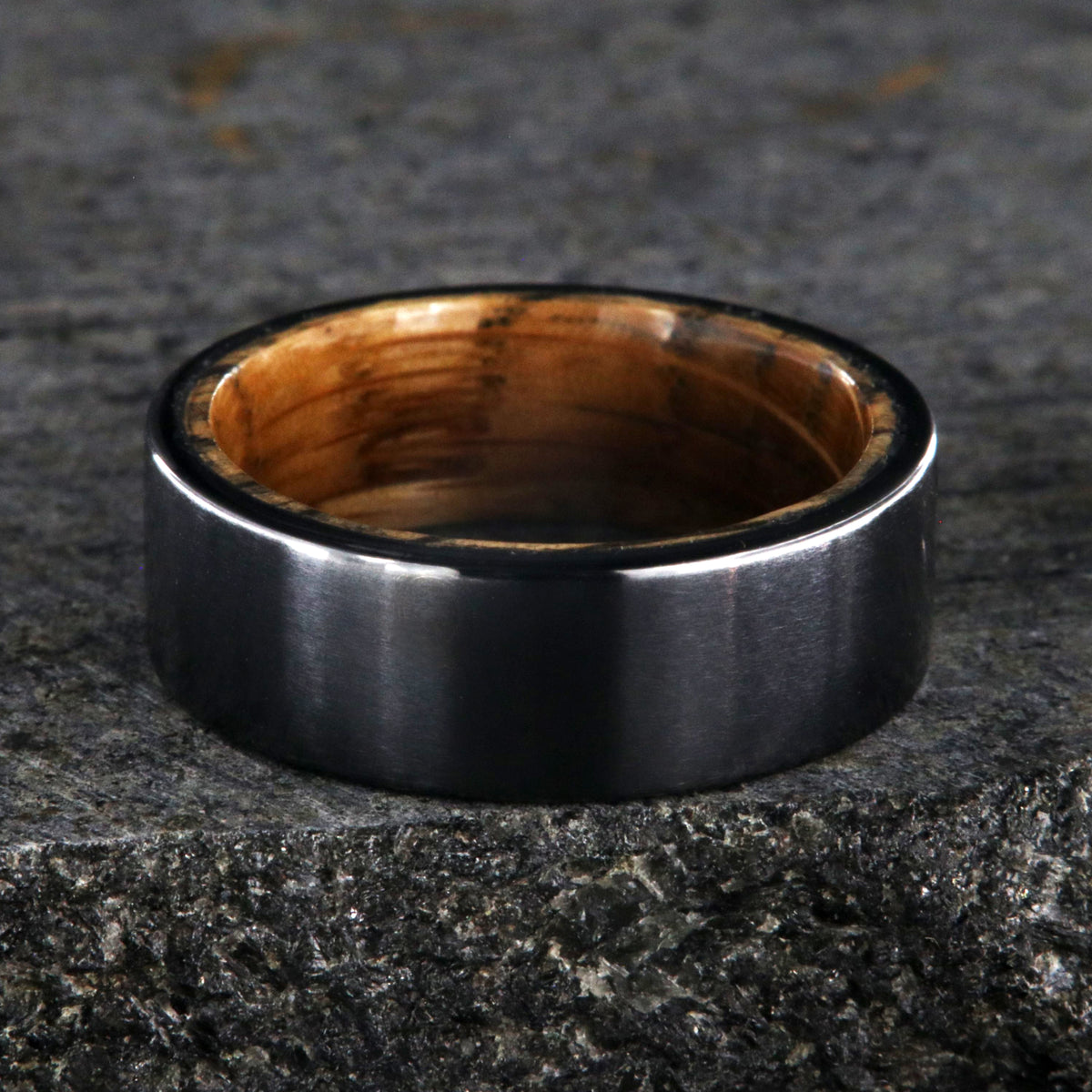 8mm wide black titanium wedding band with a whiskey barrel sleeve and flat profile