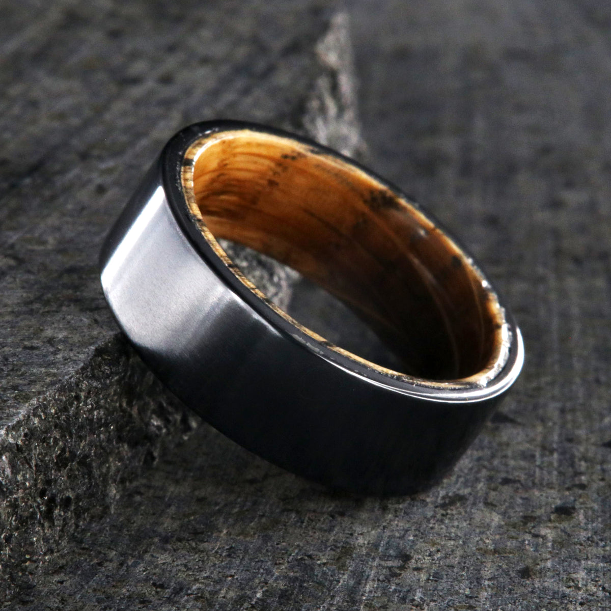 8mm wide black titanium wedding band with a whiskey barrel sleeve and flat profile