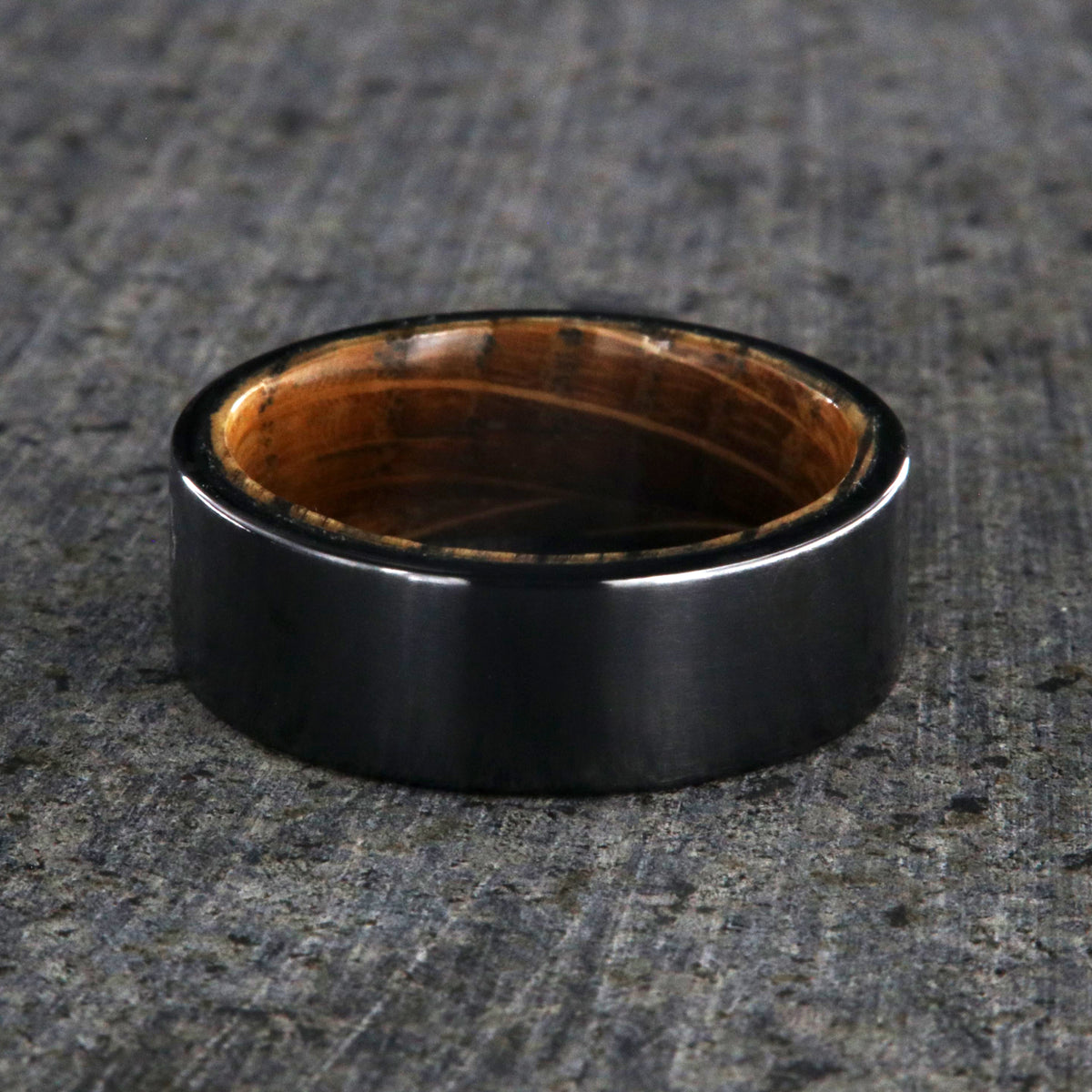 8mm wide black titanium wedding band with a whiskey barrel sleeve and flat profile