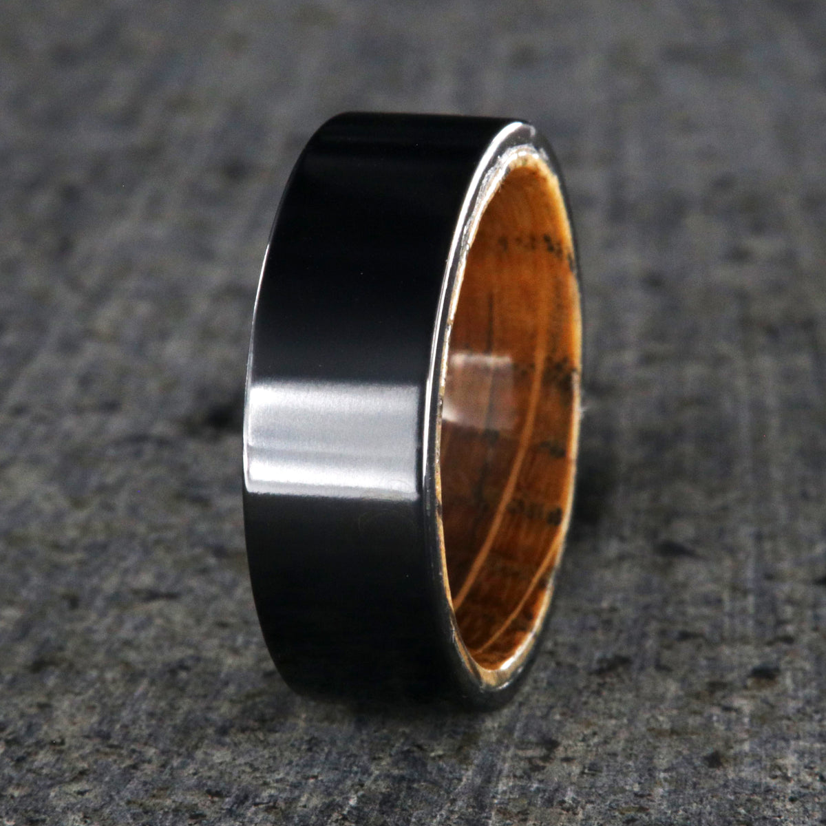 8mm wide black titanium wedding band with a whiskey barrel sleeve and flat profile