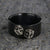 10mm wide black zirconium wedding band with an etched pair of die and a flat profile