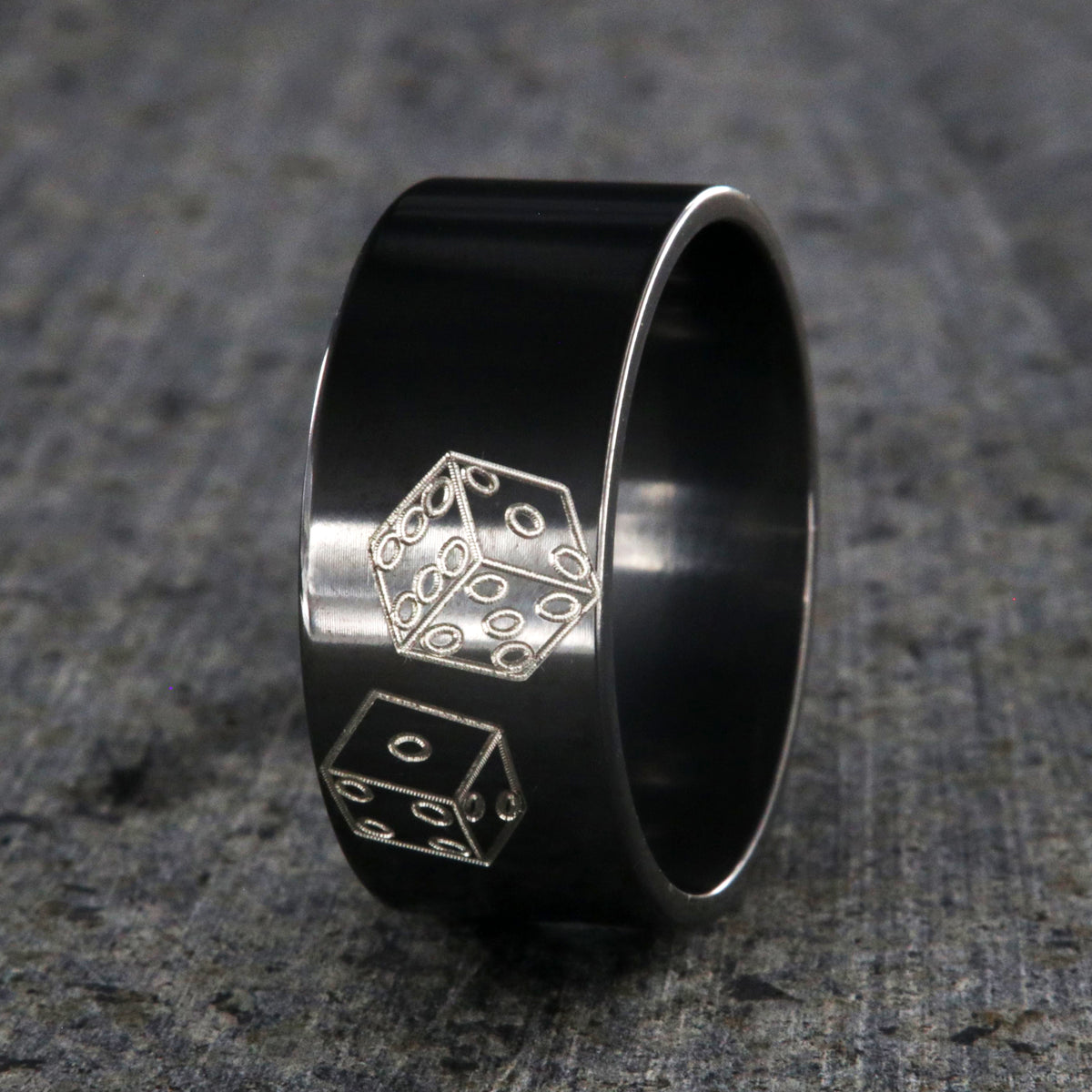 10mm wide black zirconium wedding band with an etched pair of die and a flat profile