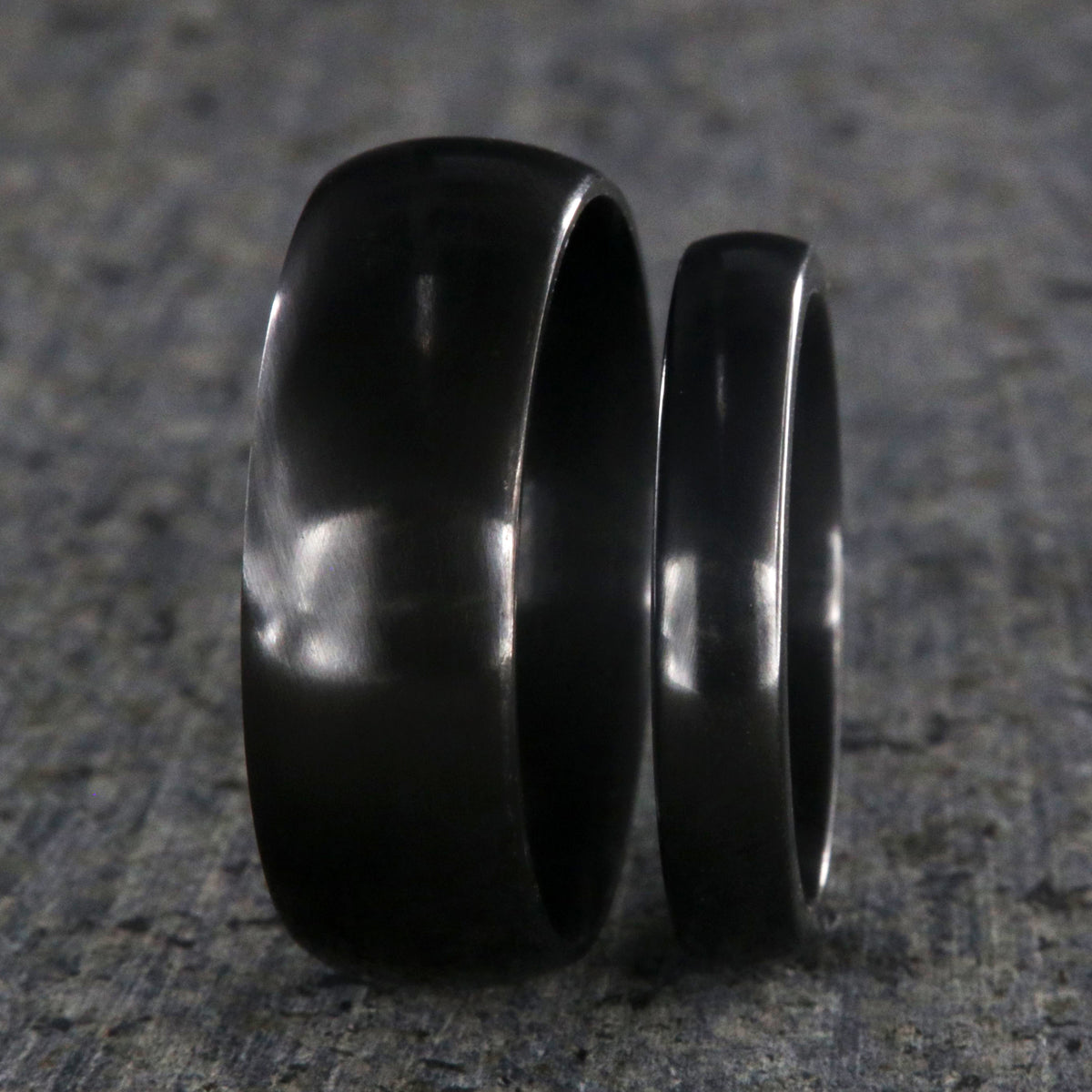 8mm and 4mm wide matching black zirconium wedding ring set with a polished finish and rounded profile